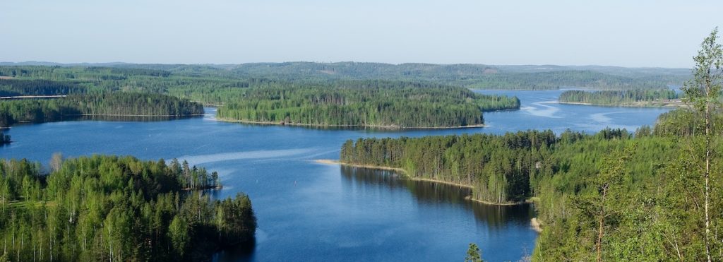 Näkymä Neitvuoren huipulta kohti sinistä järvimaisemaa, jossa metsäisiä saaria.